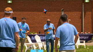 People play cornhole at an event