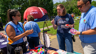 Visitors gather around display tables