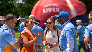 People engaged in conversation in front of the giant inflatable liver