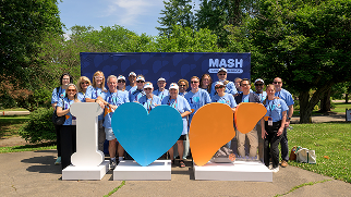 Attendees pose for a group photo with an I heart liver display