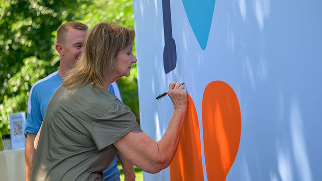 Woman signs the Liver Health Pledge wall